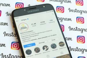 National Geographic official instagram account on smartphone screen on paper instagram banner. photo
