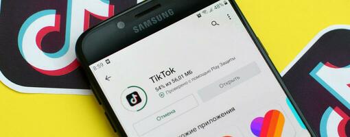 Tik Tok solicitud en mercado de juego en Samsung teléfono inteligente pantalla en amarillo antecedentes. Tik Tok es un popular compartir videos social redes Servicio poseído por bytedance foto