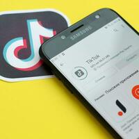 Tik Tok solicitud en mercado de juego en Samsung teléfono inteligente pantalla en amarillo antecedentes. Tik Tok es un popular compartir videos social redes Servicio poseído por bytedance foto