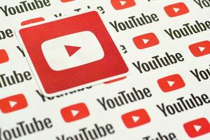 Youtube logo sticker on pattern printed on paper with small youtube logos and inscriptions. YouTube is Google subsidiary and American most popular video-sharing platform photo