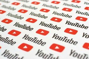 Youtube pattern printed on paper with small youtube logos and inscriptions. YouTube is Google subsidiary and American most popular video-sharing platform photo