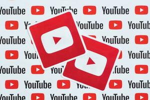 Youtube logo sticker on pattern printed on paper with small youtube logos and inscriptions. YouTube is Google subsidiary and American most popular video-sharing platform photo