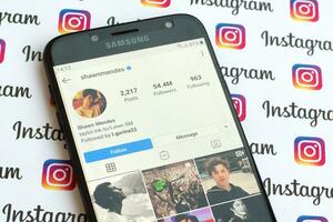 Shawn Mendes official instagram account on smartphone screen on paper instagram banner. photo