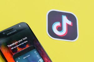 Tik Tok solicitud en Samsung teléfono inteligente pantalla en amarillo antecedentes. Tik Tok es un popular compartir videos social redes Servicio poseído por bytedance foto