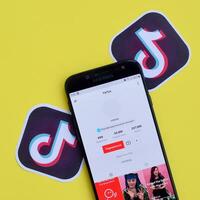 Tik Tok solicitud en Samsung teléfono inteligente pantalla en amarillo antecedentes. Tik Tok es un popular compartir videos social redes Servicio poseído por bytedance foto