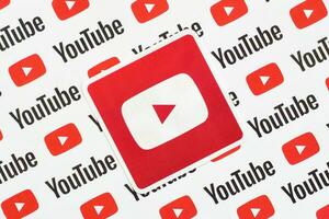 Youtube logo sticker on pattern printed on paper with small youtube logos and inscriptions. YouTube is Google subsidiary and American most popular video-sharing platform photo