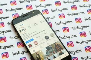 Zara official instagram account on smartphone screen on paper instagram banner. photo