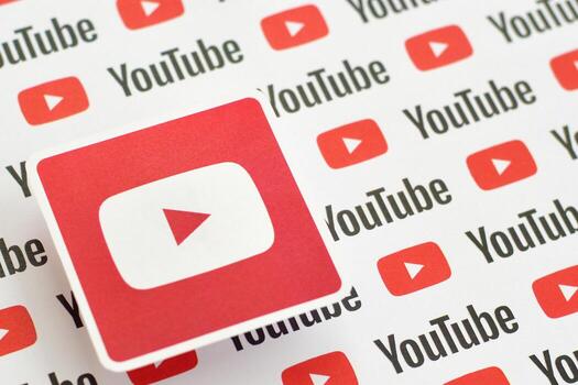 Youtube logo sticker on pattern printed on paper with small youtube logos and inscriptions. YouTube is Google subsidiary and American most popular video-sharing platform photo