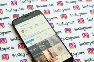 Chanel official instagram account on smartphone screen on paper instagram banner. photo