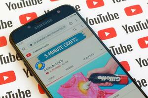 5-Minute Crafts official youtube channel on smartphone screen on paper youtube background. photo