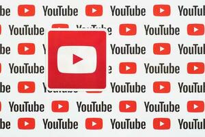 Youtube logo sticker on pattern printed on paper with small youtube logos and inscriptions. YouTube is Google subsidiary and American most popular video-sharing platform photo