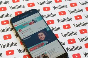 Whinderssonnunes official youtube channel on smartphone screen on paper youtube background. photo