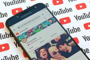 ElrubiusOMG official youtube channel on smartphone screen on paper youtube background. photo