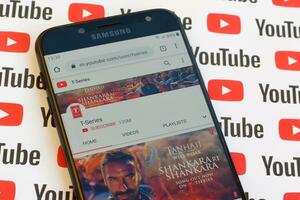 T-series official youtube channel on smartphone screen on paper youtube background. photo