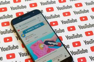 5-Minute Crafts official youtube channel on smartphone screen on paper youtube background. photo