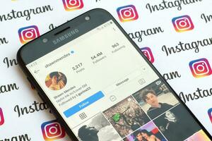 Shawn Mendes official instagram account on smartphone screen on paper instagram banner. photo