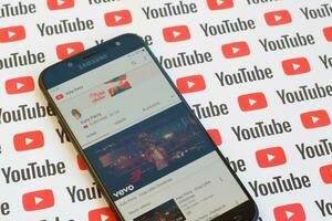 Katy Perry official youtube channel on smartphone screen on paper youtube background. photo