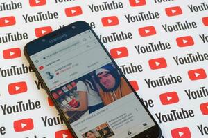 JuegaGerman official youtube channel on smartphone screen on paper youtube background. photo