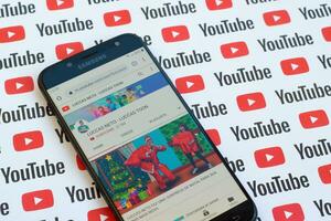 Luccas Neto - Luccas toon official youtube channel on smartphone screen on paper youtube background. photo