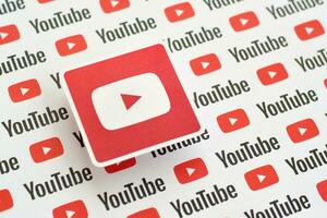 Youtube logo sticker on pattern printed on paper with small youtube logos and inscriptions. YouTube is Google subsidiary and American most popular video-sharing platform photo