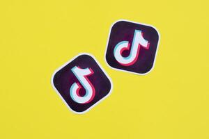 Tiktok paper logo on yellow background. TikTok is a popular video-sharing social networking service owned by ByteDance photo