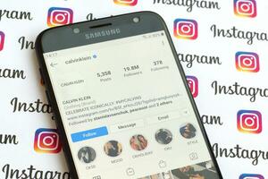 Calvin Klein official instagram account on smartphone screen on paper instagram banner. photo