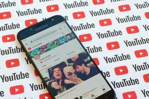 ElrubiusOMG official youtube channel on smartphone screen on paper youtube background. photo