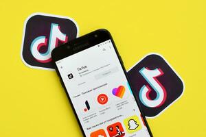 Tik Tok solicitud en mercado de juego en Samsung teléfono inteligente pantalla en amarillo antecedentes. Tik Tok es un popular compartir videos social redes Servicio poseído por bytedance foto