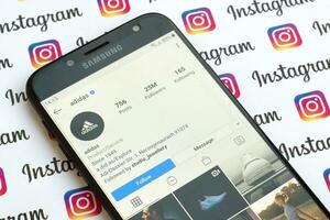adidas oficial instagram cuenta en teléfono inteligente pantalla en papel instagram bandera. foto