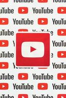 Youtube logo sticker on pattern printed on paper with small youtube logos and inscriptions. YouTube is Google subsidiary and American most popular video-sharing platform photo