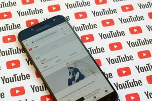 ibighit official youtube channel on smartphone screen on paper youtube background. photo