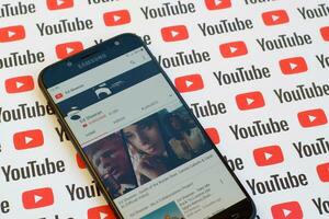 Ed Sheeran official youtube channel on smartphone screen on paper youtube background. photo