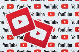 Youtube logo sticker on pattern printed on paper with small youtube logos and inscriptions. YouTube is Google subsidiary and American most popular video-sharing platform photo