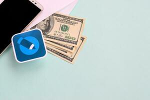 Livejournal paper logo lies with envelope full of dollar bills and smartphone photo