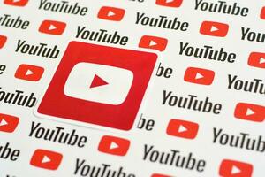 Youtube logo sticker on pattern printed on paper with small youtube logos and inscriptions. YouTube is Google subsidiary and American most popular video-sharing platform photo