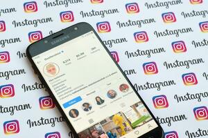 Ellen DeGeneres official instagram account on smartphone screen on paper instagram banner. photo