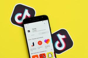 Tik Tok solicitud en mercado de juego en Samsung teléfono inteligente pantalla en amarillo antecedentes. Tik Tok es un popular compartir videos social redes Servicio poseído por bytedance foto