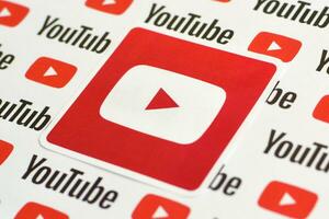 Youtube logo sticker on pattern printed on paper with small youtube logos and inscriptions. YouTube is Google subsidiary and American most popular video-sharing platform photo