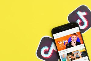 Tik Tok solicitud en Samsung teléfono inteligente pantalla en amarillo antecedentes. Tik Tok es un popular compartir videos social redes Servicio poseído por bytedance foto