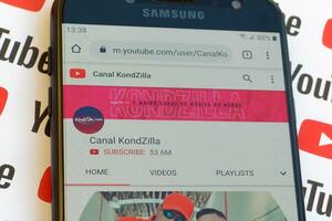 Canal KondZilla official youtube channel on smartphone screen on paper youtube background. photo