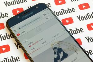 ibighit official youtube channel on smartphone screen on paper youtube background. photo