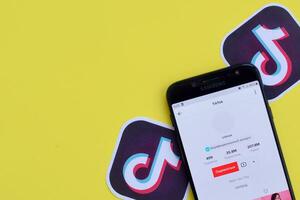 Tik Tok solicitud en Samsung teléfono inteligente pantalla en amarillo antecedentes. Tik Tok es un popular compartir videos social redes Servicio poseído por bytedance foto