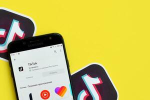 Tik Tok solicitud en mercado de juego en Samsung teléfono inteligente pantalla en amarillo antecedentes. Tik Tok es un popular compartir videos social redes Servicio poseído por bytedance foto