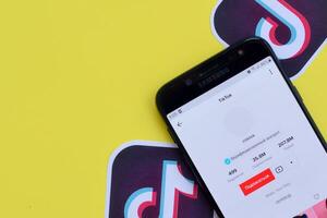 Tik Tok solicitud en Samsung teléfono inteligente pantalla en amarillo antecedentes. Tik Tok es un popular compartir videos social redes Servicio poseído por bytedance foto