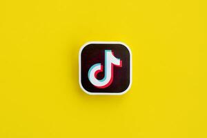 Tiktok paper logo on yellow background. TikTok is a popular video-sharing social networking service owned by ByteDance photo