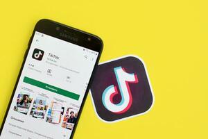 Tik Tok solicitud en mercado de juego en Samsung teléfono inteligente pantalla en amarillo antecedentes. Tik Tok es un popular compartir videos social redes Servicio poseído por bytedance foto