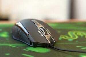 P93 Bloody cybersport gaming mouse by A4Tech lies on Razer Goliathus mouse pad. Professional cybersport supply photo