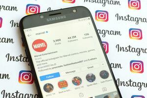 Marvel official instagram account on smartphone screen on paper instagram banner. photo