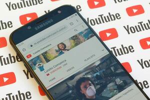 Luisito Comunica official youtube channel on smartphone screen on paper youtube background. photo