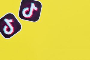 Tiktok paper logo on yellow background. TikTok is a popular video-sharing social networking service owned by ByteDance photo